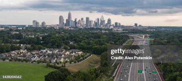 interstate 77 with the traffic on it in the evening, with a distant view of downtown in charlotte, north carolina, usa, against the stormy sky. extra-large, high resolution stitched panorama. - charlotte north carolina landmarks stock pictures, royalty-free photos & images