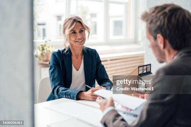 real estate agent and client discussing with each other at office - real estate office stockfoto's en -beelden