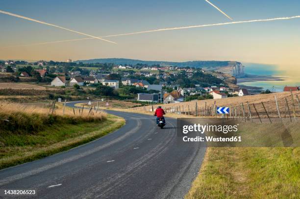 france, normandy, criel-sur-mer, motorcycle driving along country road - seine maritime photos et images de collection