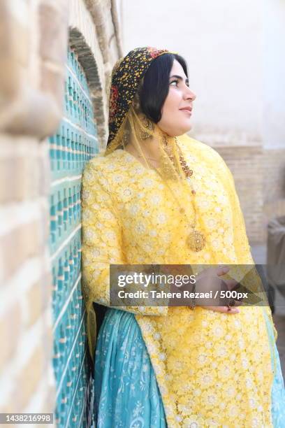 woman in traditional clothing looking away while standing against wall,iran - traditional clothing stock pictures, royalty-free photos & images