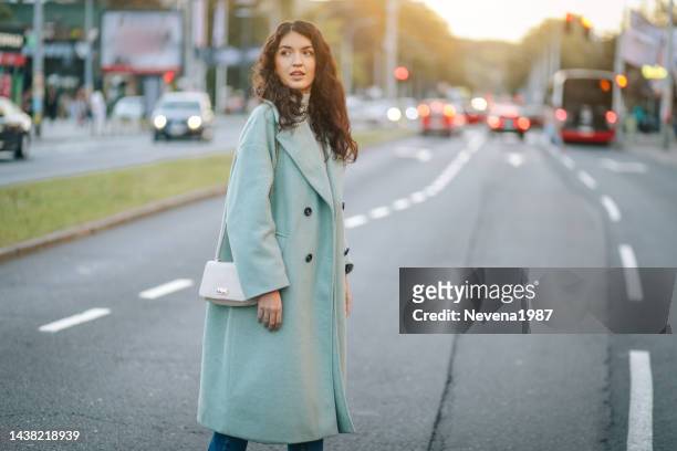 mulher da moda atravessando uma rua na cidade - camel active - fotografias e filmes do acervo