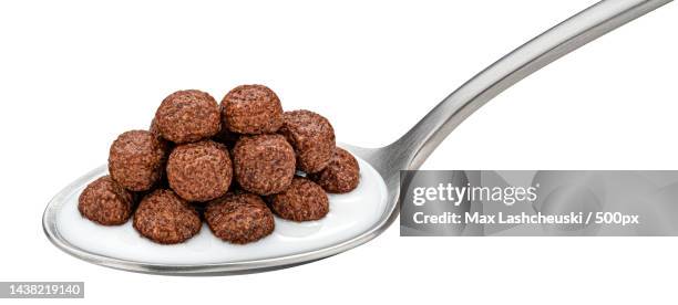 chocolate corn balls with milk in spoon isolated on white background - chocolate milk splash stock pictures, royalty-free photos & images