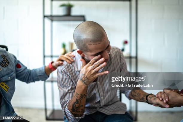 junger mann weint während der therapie im psychiatrischen zentrum - half shaved hairstyle stock-fotos und bilder
