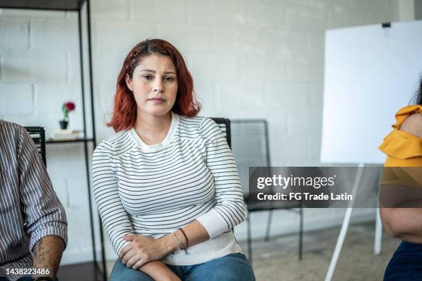 portrait of sad mid adult woman during a group therapy - distraught portrait stock pictures, royalty-free photos & images