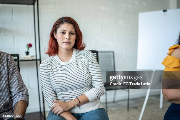 portrait of sad mid adult woman during a group therapy - vulnerability stock pictures, royalty-free photos & images