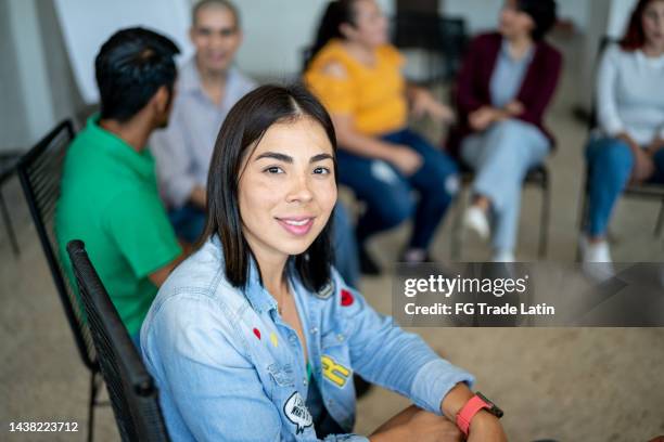 portrait of mid adult woman during a group therapy at mental health center - neighbours talking stock pictures, royalty-free photos & images