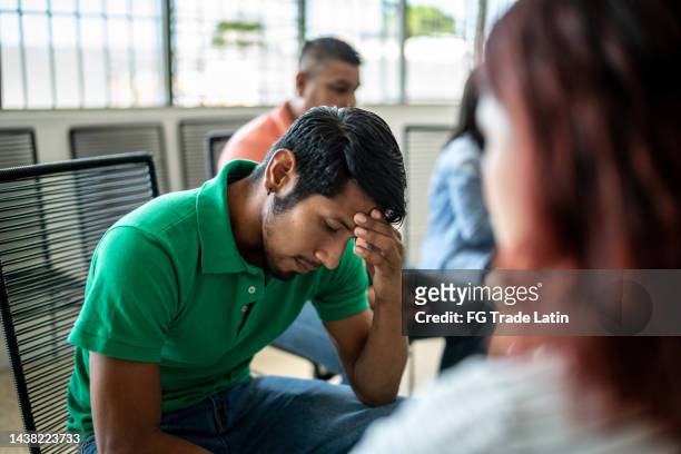 depressed mid adult man during a group therapy - ongerechtigheid stockfoto's en -beelden