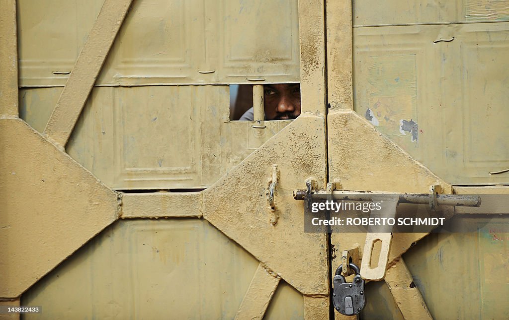 A man peeks through an opening of a door