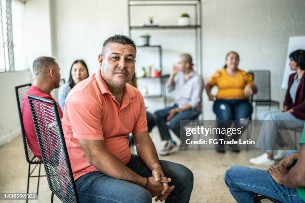 portrait of mid adult man during a group therapy at mental health center - man reliable learning stockfoto's en -beelden