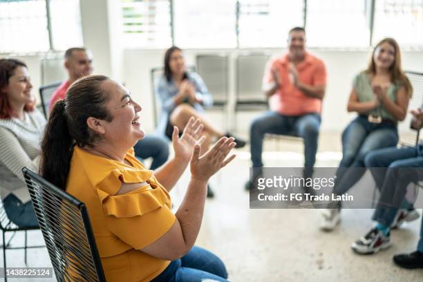 mid adult woman applauding during a presentation - charity education stock pictures, royalty-free photos & images