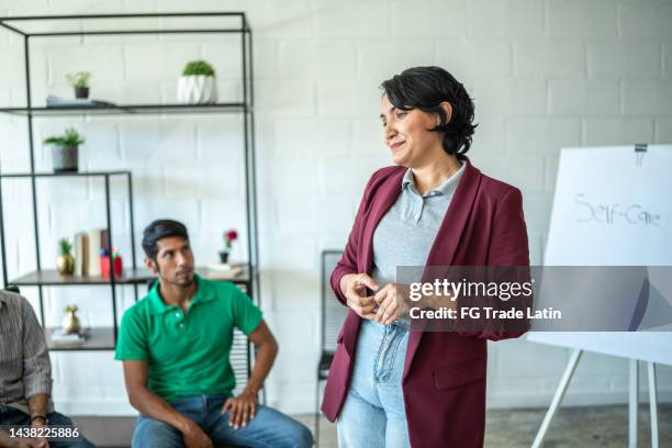 mid adult woman doing a presentation during meeting - education events stockfoto's en -beelden