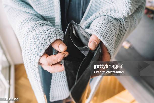 hands of man wrapped in blanket holding empty wallet - poverty stock pictures, royalty-free photos & images