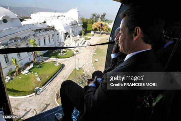 France's President Nicolas Sarkozy and Haitian President Rene Preval look at Haitian Presidential Palace during a flight in helicopter over...