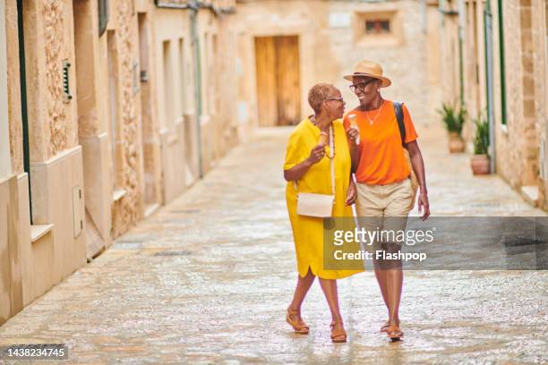 two mature women walking together - travel fotografías e imágenes de stock