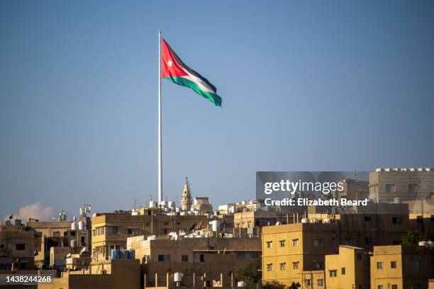 the jordanian flag flies over the hills of amman - amman imagens e fotografias de stock