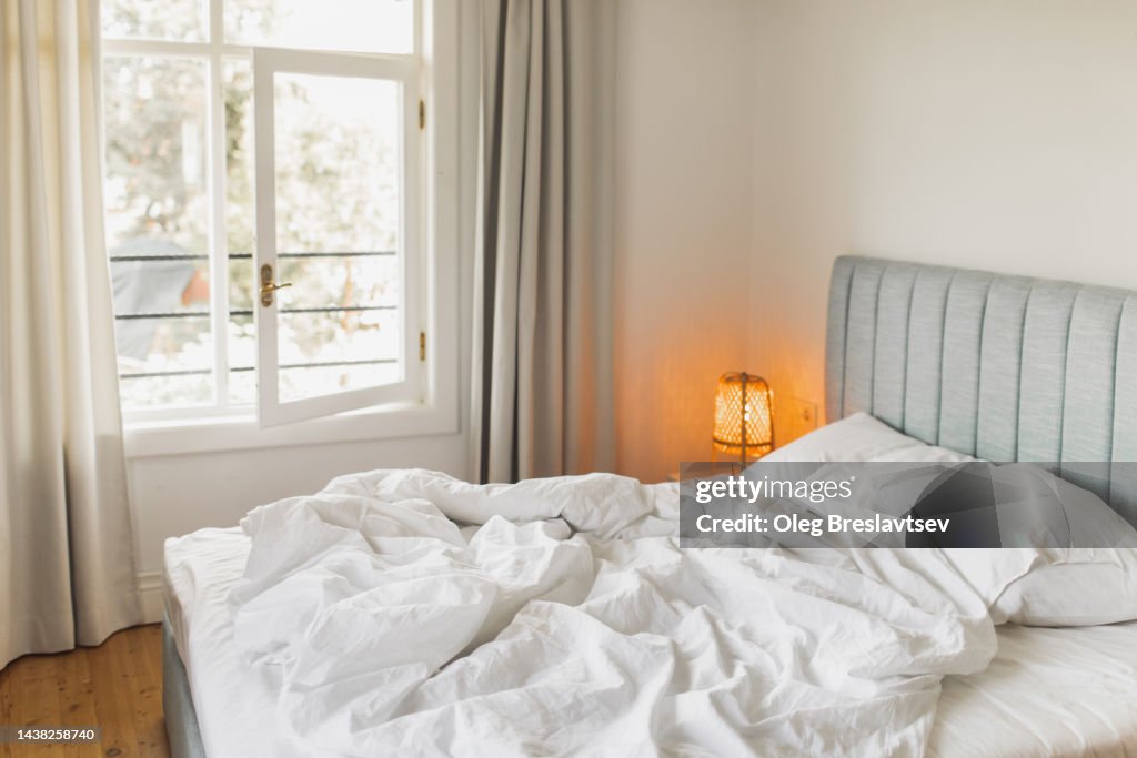 Bed in hotel room with crumpled blanket. Awakening concept. Travel and vacations