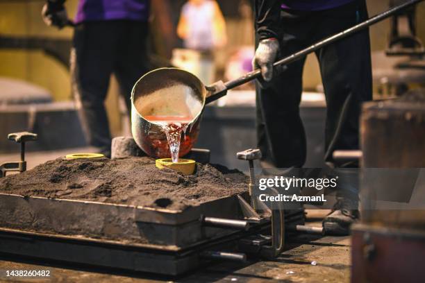 hot liquid metal being poured into a mold - molten stock pictures, royalty-free photos & images