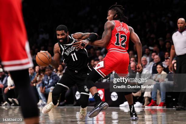 Kyrie Irving of the Brooklyn Nets is defended by Ayo Dosunmu of the Chicago Bulls during the fourth quarter of the game at Barclays Center on...