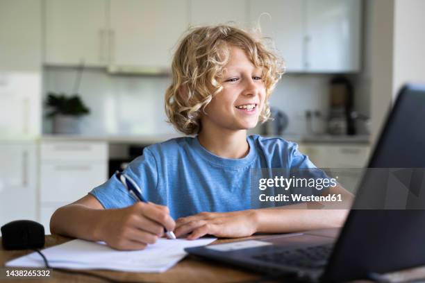 happy boy doing homework watching laptop at home - boy computer smile fotografías e imágenes de stock