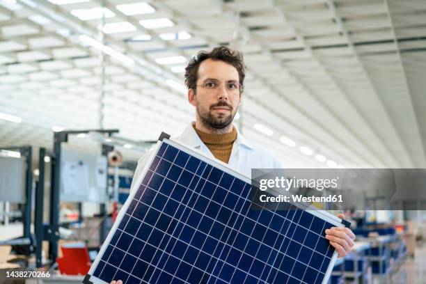 engineer with solar panel standing at industry - distribution warehouse stock-fotos und bilder