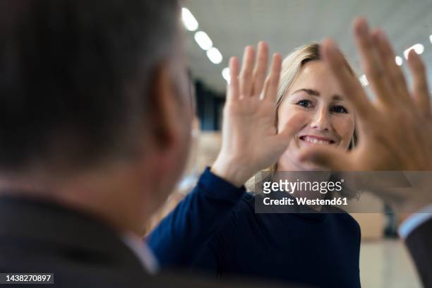 happy businesswoman giving high-five to colleague - high five business stock-fotos und bilder