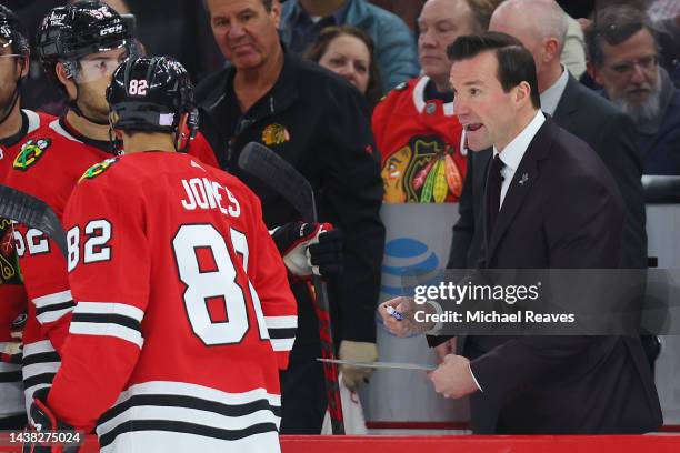 Head coach Luke Richardson of the Chicago Blackhawks talks with Caleb Jones against the New York Islanders during the third period at United Center...