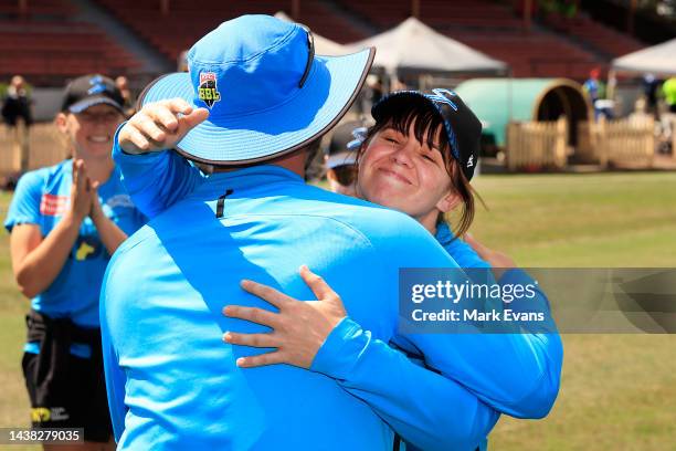 Tegan McPharlin of the Strikers is hugged by Luke Williams, head coach of the Strikers after receiving her cap for 100 games during the Women's Big...