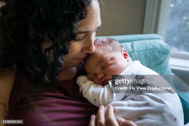 loving mom snuggling sleeping newborn baby - newborn sleeping stock pictures, royalty-free photos & images
