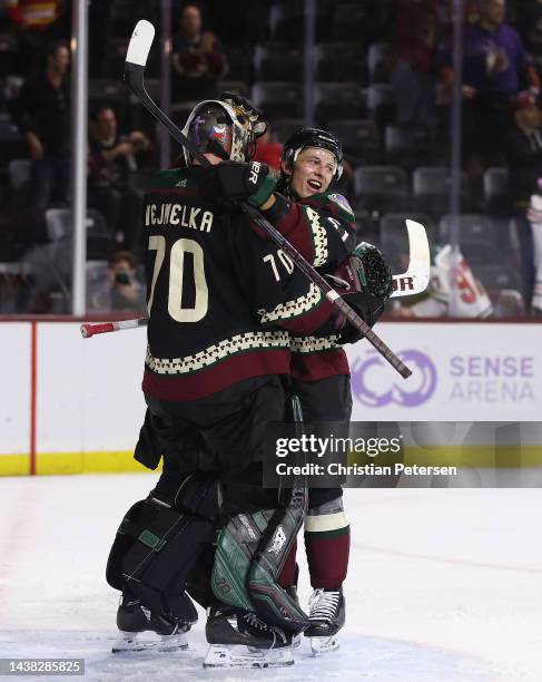 Troy Stecher and goaltender Karel Vejmelka of the Arizona Coyotes celebrate after defeating the Florida Panthers in the NHL game at Mullett Arena on...