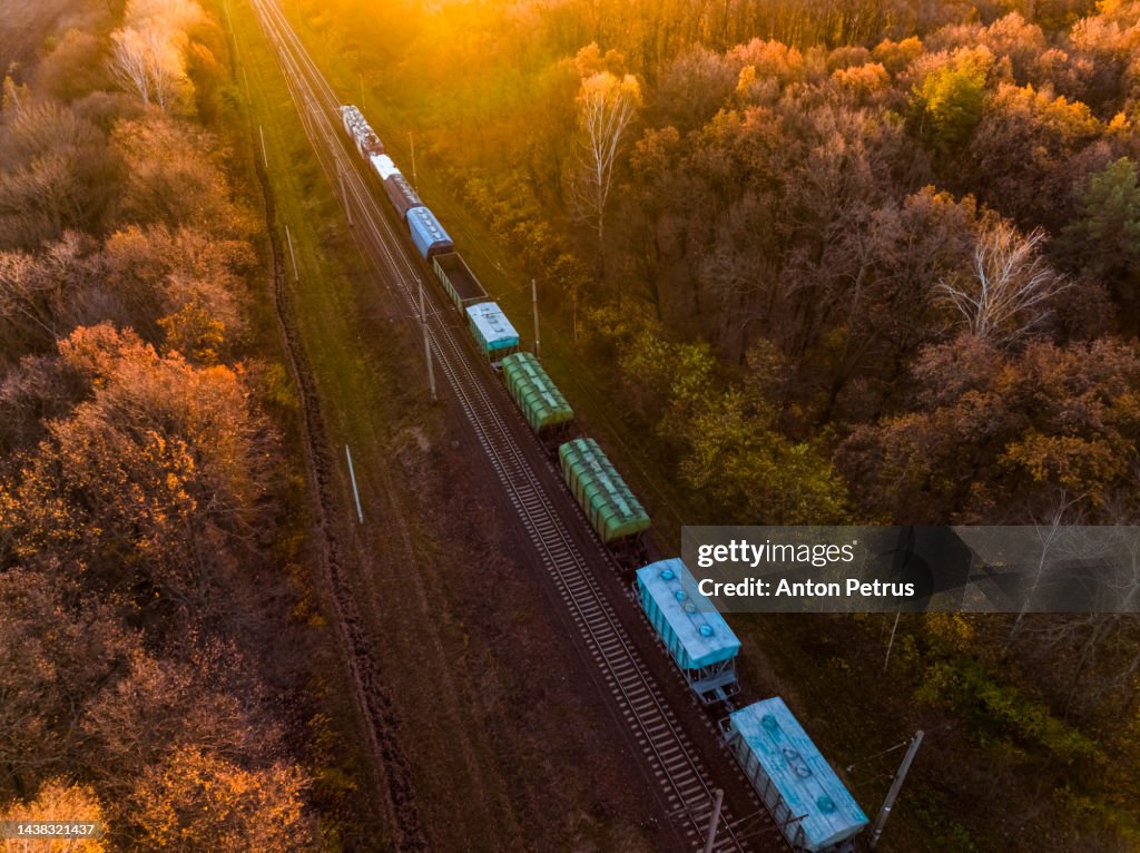 Aerial view of a freight train at dawn in autumn. Railroad transportation