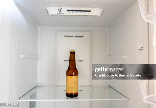 bottle of beer in the fridge at home. - beer fridge stock-fotos und bilder