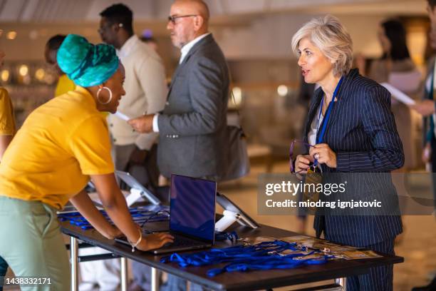 business people registering for a conference event in a hotel lobby - register bildbanksfoton och bilder