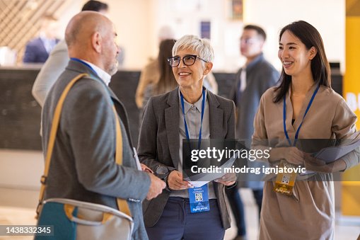 Geschäftsleute treffen sich in der Lobby eines Hotels, bevor eine Konferenzveranstaltung beginnt Geschäftsleute treffen sich in der Lobby eines Hotels, bevor eine Konferenzveranstaltung beginnt
