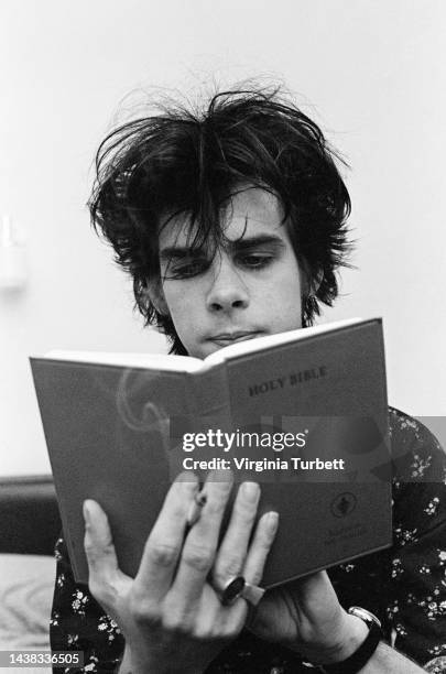 Nick Cave, lead singer of the Birthday Party, portrait holding a bible, Leeds, United Kingdom, 23rd June 1981.