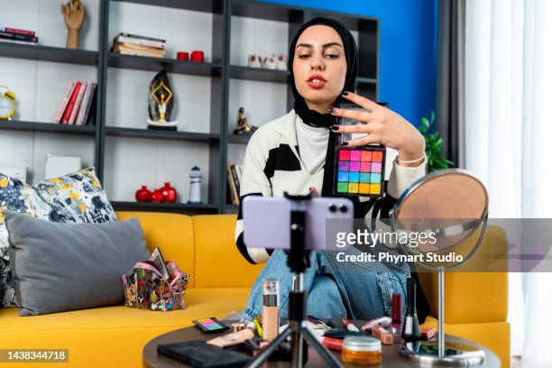 muslim beauty blogger present beauty cosmetics sitting in front camera for recording video - social content stock pictures, royalty-free photos & images