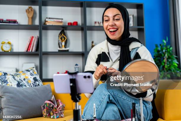 muslim beauty blogger present beauty cosmetics sitting in front camera for recording video - social content stock pictures, royalty-free photos & images