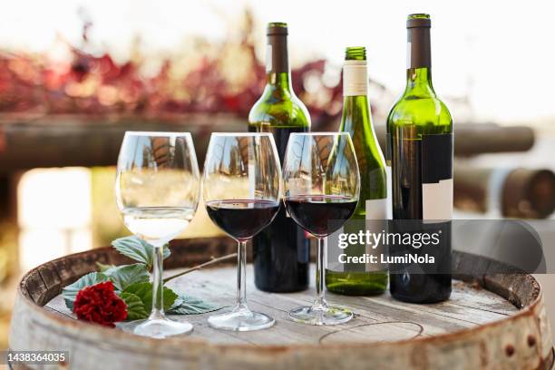 wine, glasses and vineyard on barrel of drinks for tasting in luxury wealth for fine dining in the outdoors. many different bottles of rich alcohol at winery for celebration, event or restaurant - rum tasting stock pictures, royalty-free photos & images