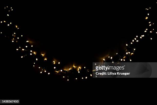 abstract black background with christmas glowing garland. - christmas tree lights stock-fotos und bilder