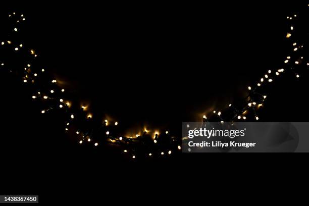 abstract black background with christmas glowing garland. - kerstverlichting stockfoto's en -beelden