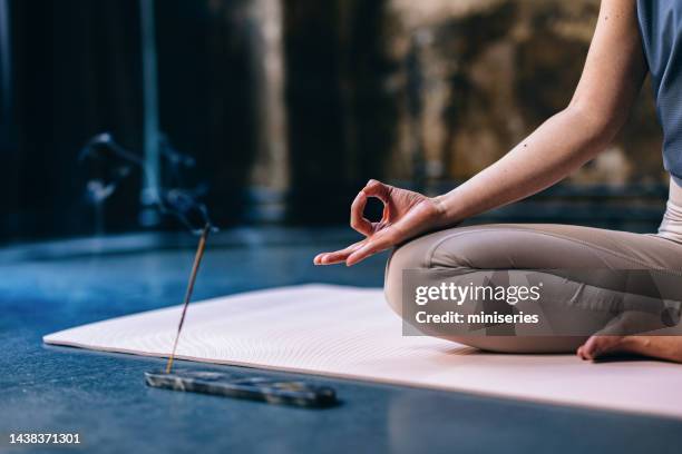 eine anonyme frau, die während der yoga-sitzung räucherstäbchen genießt - räucherwerk stock-fotos und bilder