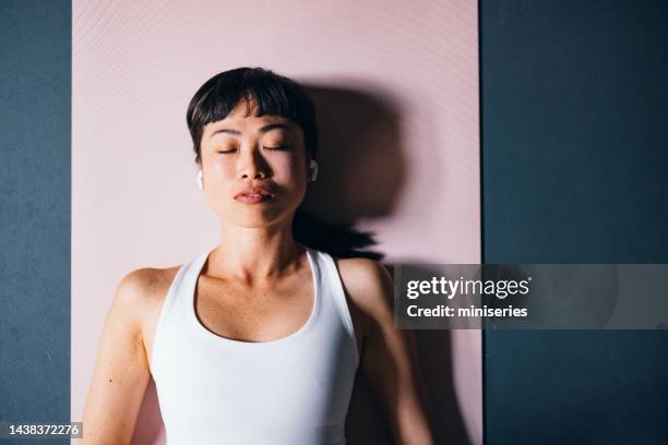 high angle view of beautiful woman lying on exercise mat and meditating - savasana stock pictures, royalty-free photos & images