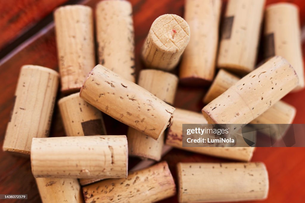 Background, wine and cork with a collection or group of alcohol caps or objects on a red background from above. Texture, wood and luxury with many corks in a pile or stack on a wine farm and cellar