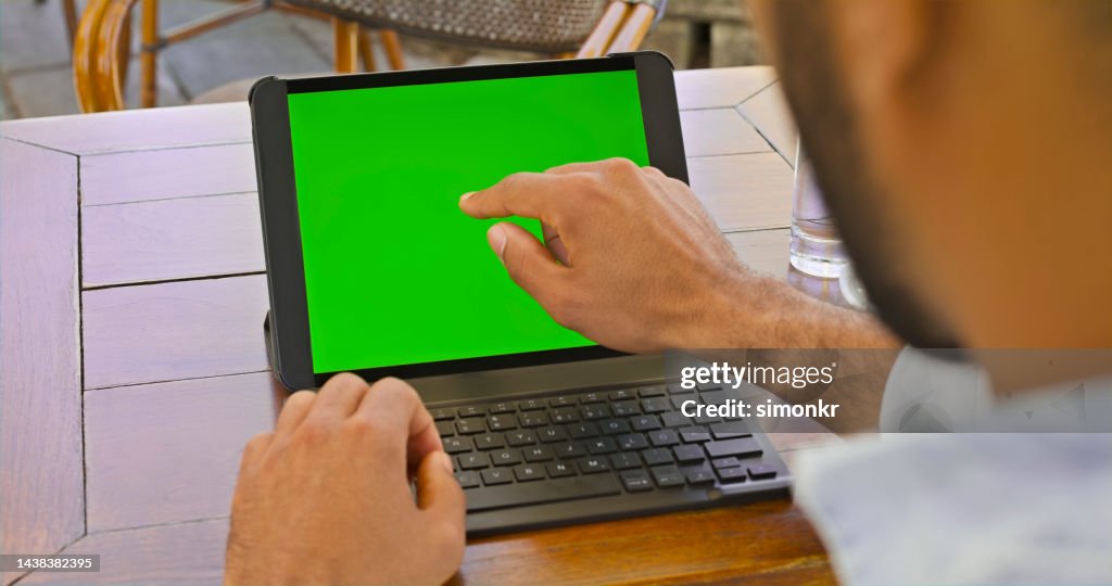 Primer plano del hombre tocando la pantalla de la computadora portátil