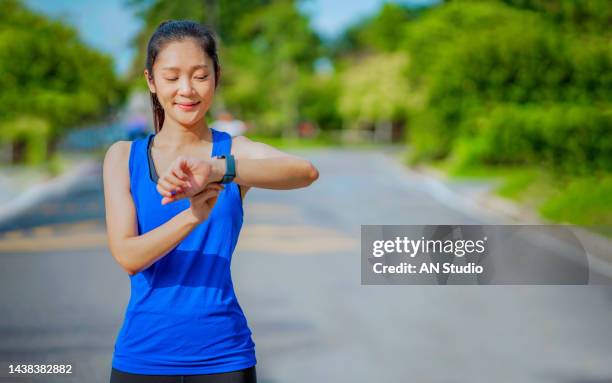 women setting up the fitness smart watch for running. young fitness women runner checking time from smart watch. young woman checking heart rate while jogging in the park. - running gear stock pictures, royalty-free photos & images