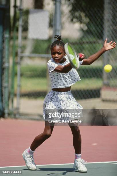 Tennis player Serena Williams from the United States plays a double handed backhand return over the net during a training session on 1st August 1990...