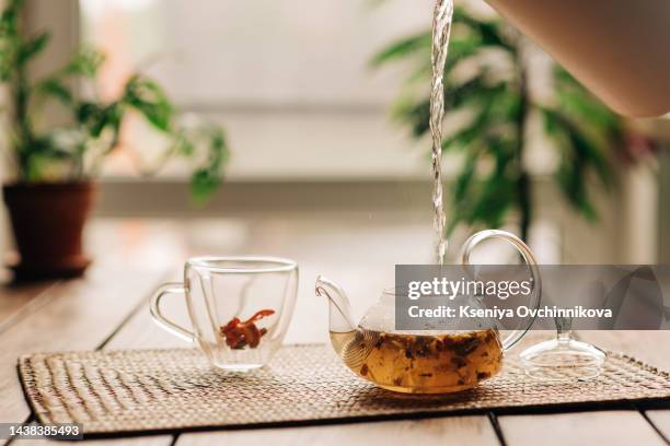 tea with sea buckthorn in glass teapot, selective focus, rustic background, square image - tea cup photos et images de collection