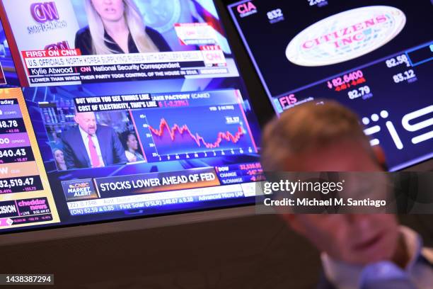 Financial news is seen on a television as traders work on the floor of the New York Stock Exchange during morning trading on November 02, 2022 in New...