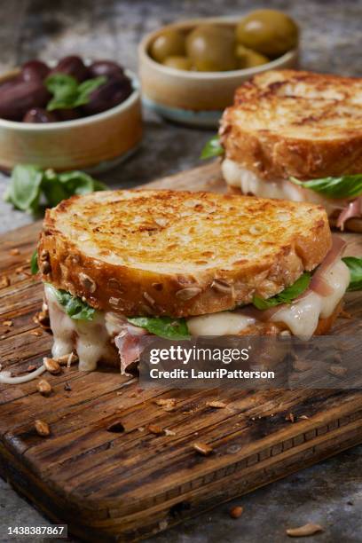 grilled cheese with prosciutto and brie - tosti stockfoto's en -beelden