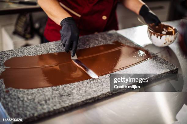 woman making and decorating cakes in cake manufacture industry - chocolate cake stockfoto's en -beelden