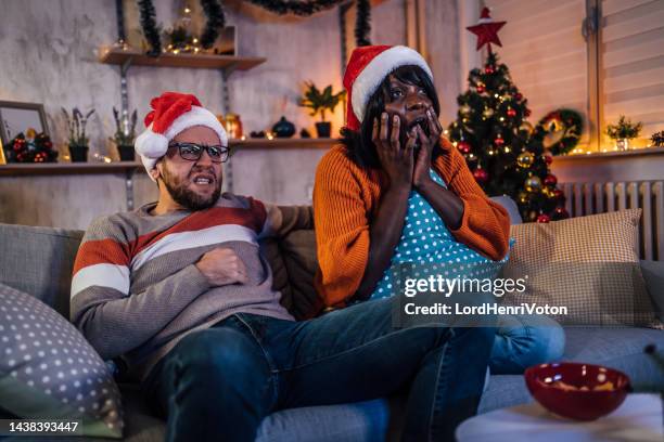 couple scared by horror movie - christmas movie stock pictures, royalty-free photos & images